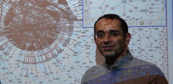 Professor Zoubin Ghahramani in front of a graph visualising how people search for information on MSN.