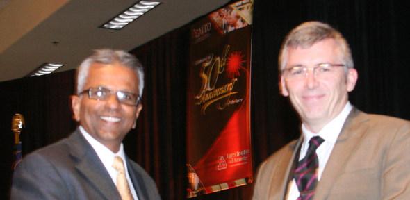 Dr O'Neill (right) receiving his award from the President Dr Raj Patel