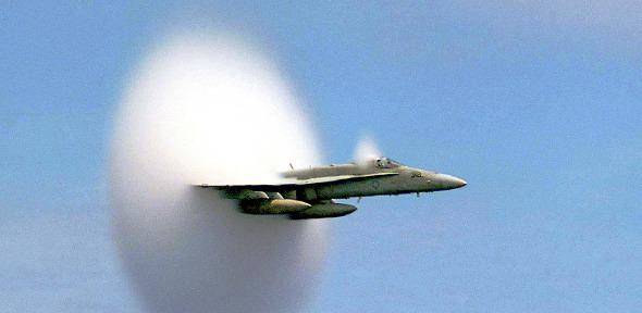 A cloud forms as this F/A-18 Hornet aircraft speeds up to supersonic speed