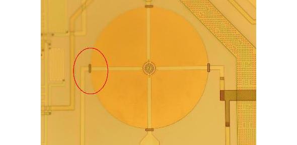 Photograph showing an SOI microhotplate (large circle) with a small micro-heater (12 micron radius)