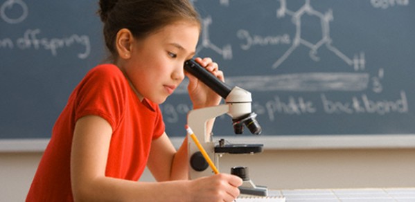 Schoolgirl Looking Through Microscope