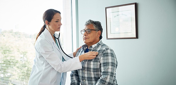 Doctor listening to a man's heart with a stethoscope
