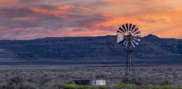 Windmill in Karoo during sunset in Eastern and Western Cape, South Africa.