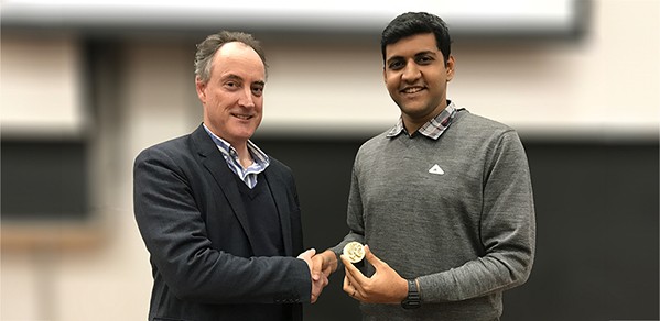 The 2023 Helios Prize winner Parth Deshpande, right, accepts his award of prize money and a brass medal, from the Head of the Department of Engineering, Professor Colm Durkan.