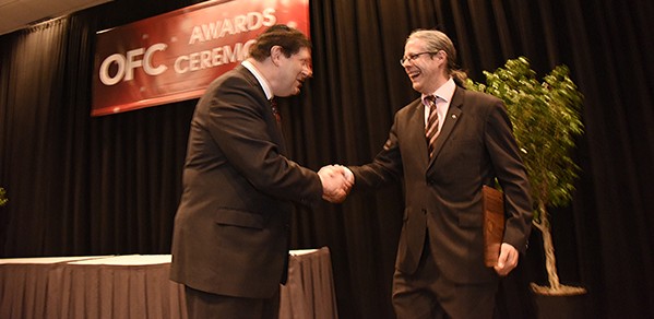Dr Savory (right) receives his OSA Fellowship from OSA Past President Professor Alan Willner.