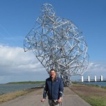 Antony Gormley in front of his sculpture