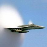 A cloud forms as this F/A-18 Hornet aircraft speeds up to supersonic speed