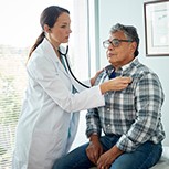Doctor listening to a man's heart with a stethoscope