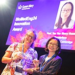 Professor Karin Hing from Queen Mary University of London stands on stage to present the BioMedEng24 Innovation Prize to Profess