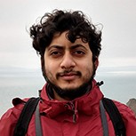 A head and shoulders shot of Dr Somenath Bakshi standing on top of a cliff with outdoor clothing on