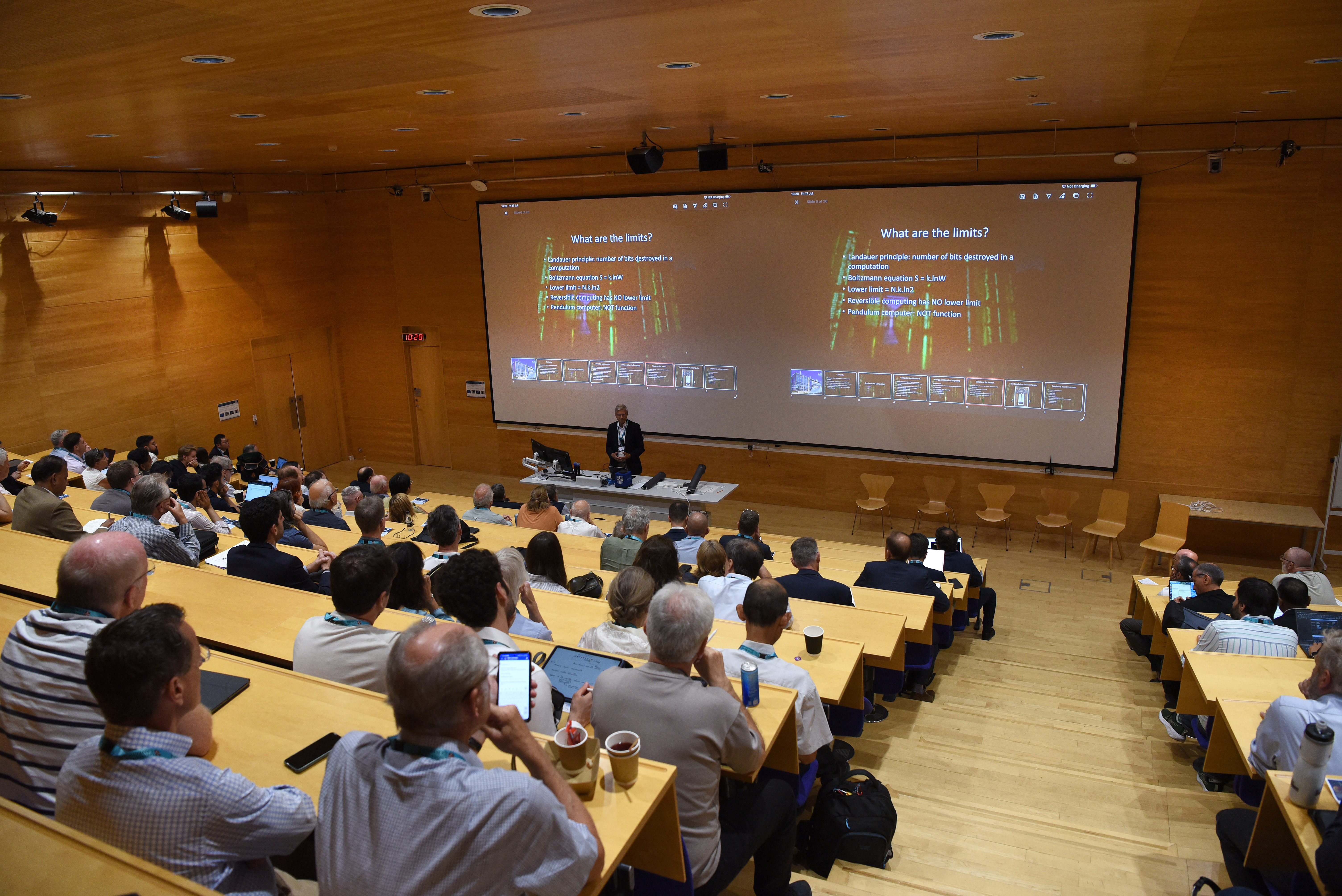 Lecture theatre full of attendees of the CGC and EE anniversary event listening to talks.